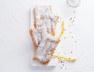 Italian Frappe or chiacchiere  - typical Italian carnival fritters dusted with powdered sugar on ...