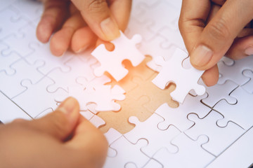 High view of a businessman jigsaw puzzles on a wooden table.