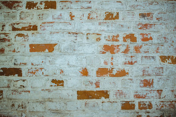 Red old worn brick wall texture background. Vintage effect. Background. Old brick wall in the background. Old brick close-up with plaster. Brick wall grunge with broken texture of plaster.