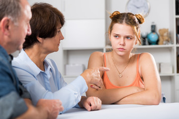 Parents are comforting the upset adult daughter at the table
