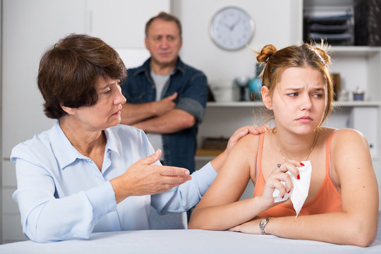 Adult woman is carefully talking with a sad daughter