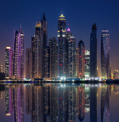 Naklejka premium Skyline von Dubai am Abend mit Wasser-Spieglung 