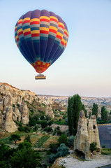Fototapeta na wymiar Hot air balloon flying over rock landscape at Cappadocia Turkey