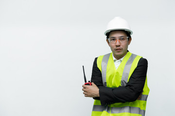 Asian engineer with wear helmet and safety glasses,He has a walkie talkie in hand,Thailand smart people