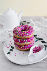 Pink doughnuts with berry filling on a light background (close-up)