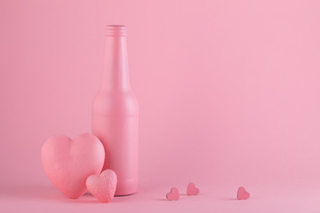 Pink mat bottle on the pink background with hearts. Love and St. Valentine's Day