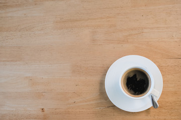 flat lay of white cup of coffee put on wooden table, with copy space