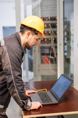 Maintenance engineer inspect relay protection system with laptop computer