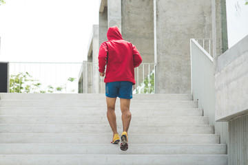 Urban athlete running upstairs. Sporty man working out outside and climbing stairs.