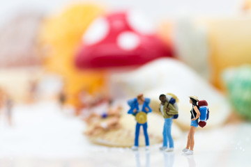Obraz premium Miniature people : Backpackers travel at beach on vacation. Image use for business travel concept.