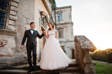Fabulous wedding couple walking around the castle territory on their festive day.