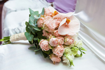 A wedding bouquet lies on a white fabric. Bridal bouquet.