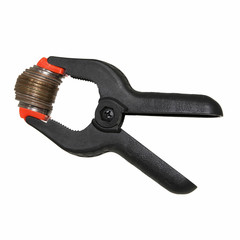 A black clamp holding coins