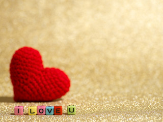 Fototapeta premium Red yarn heart with I Love You text from bead colorful on the gold floor and background copy space for text. Valentines day, love concept and love background