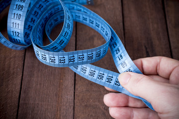 the woman takes the measuring tape from the table