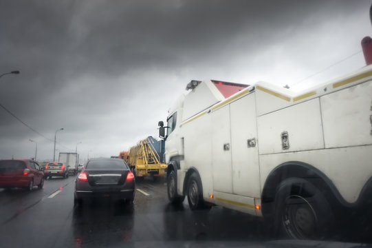 tow truck for trucks is on the road under the rain
