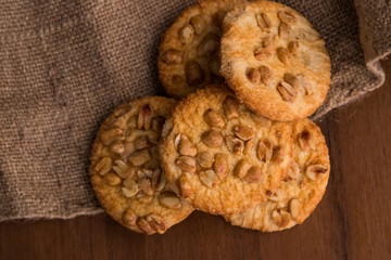 Sweet cookies with peanuts on wooden table. Top view