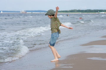 The guy is happy on the sandy beach of the sea.