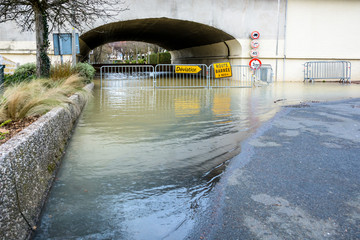 Yellow road signs installed on temporary gates show a traffic diversion in front of a tunnel...