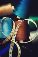 Pile of colorful spools of thread and measuring meter 