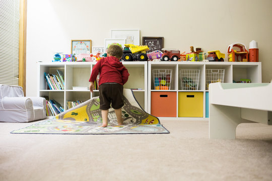 Toddler cleaning up playroom