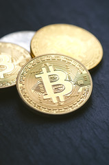 Golden bitcoin coins on a dark background with euro coins.  Virtual currency. Crypto currency. New virtual money. Lens flare 