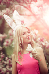 girl or cute woman with rosy, bunny ears hold magnolia