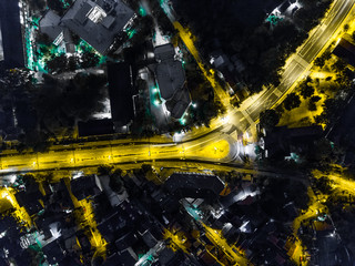 Night aerial view of a street splitting in two roads . drone road view
