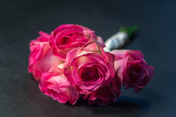 Bouquet of pink roses lying on a dark grey floor