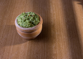 bowl of guacamole isolated on rustic table