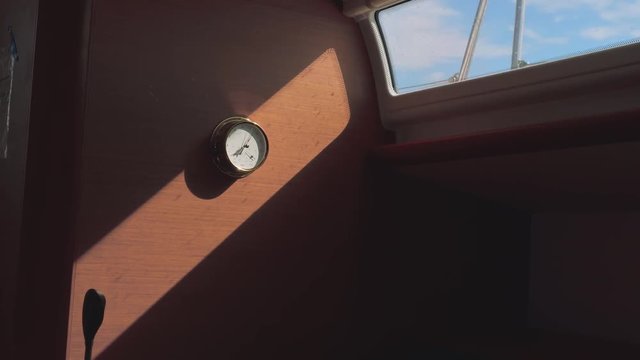 View of barometer on wall of yacht cabin in sunspot during ship motion
