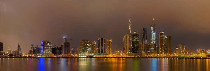 Fototapeta na wymiar Dubai - The evening skyline over the Canal and Downtown in rain.