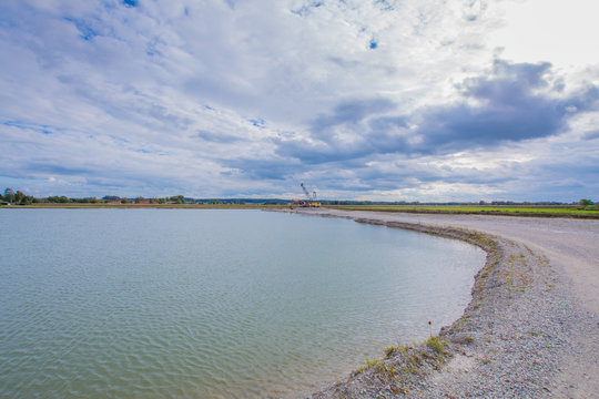 Baggersee mit Maschinen im Hintergrund