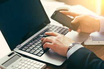 young businessman in office with smartphone tablet at workplace