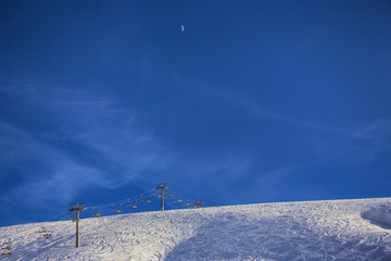 winter resort panorama with snowy hill and moon