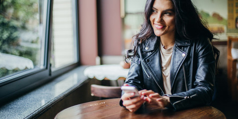 Young pretty spanish woman in cafe in city centre with tablet laptop