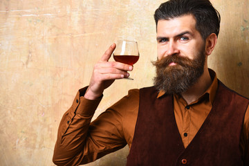 Man with beard and mustache holds alcoholic beverage