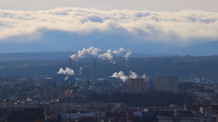 Obraz premium Fuming pipes of a refinery above the city. Europe. Poland. Podkarpatian region. December 2017.