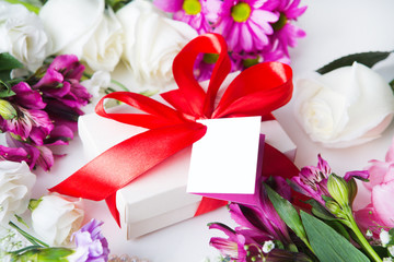 gift or present box with note and flowers on white table look with top. Womans or Mothers Day.