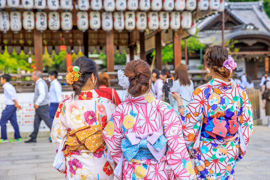 Three Japanese women in kimono take picture of paper lanterns of Yasaka Shrine in Kyoto, Japan. Gion Shrine is one of the most famous shrines in Kyoto between Gion District and Higashiyama District.