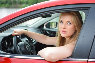 Fototapeta na wymiar Young blue-eyed blonde looks through the car window