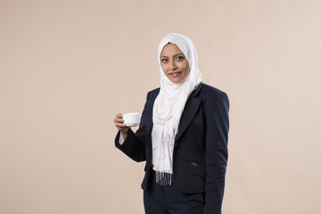 Femme arabe musulmane en hijab boit avec tasse de café