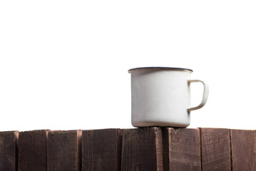 White iron mug on a wooden surface with an isolated background