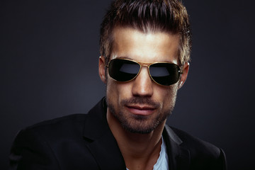 Portrait of men with sunglasses in studio on dark background