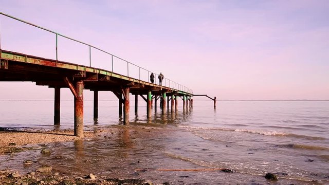 a romantic couple walking on a pier at the Tagus river, Lisbon, Portugal