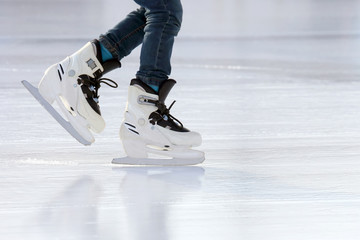 Naklejka premium feet on the skates of a person rolling on the ice rink