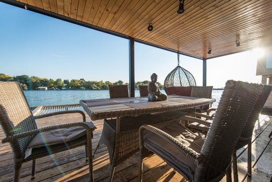 Table and seats on terrace of river floating house