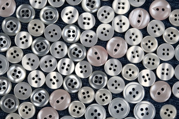 Fototapeta premium different mother of pearl buttons on blue fabric