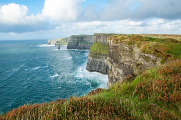 The Cliffs of Moher, Irelands Most Visited Natural Tourist Attraction, are sea cliffs located at the southwestern edge of the Burren region in County Clare, Ireland.