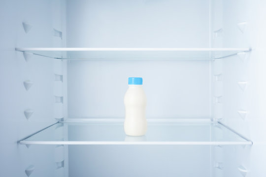 Bottle of milk in empty refrigerator